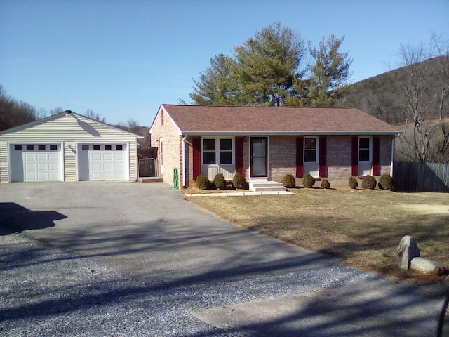 ranch-style house featuring a garage, brick siding, an outdoor structure, fence, and a front yard