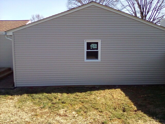 view of side of home with a shingled roof