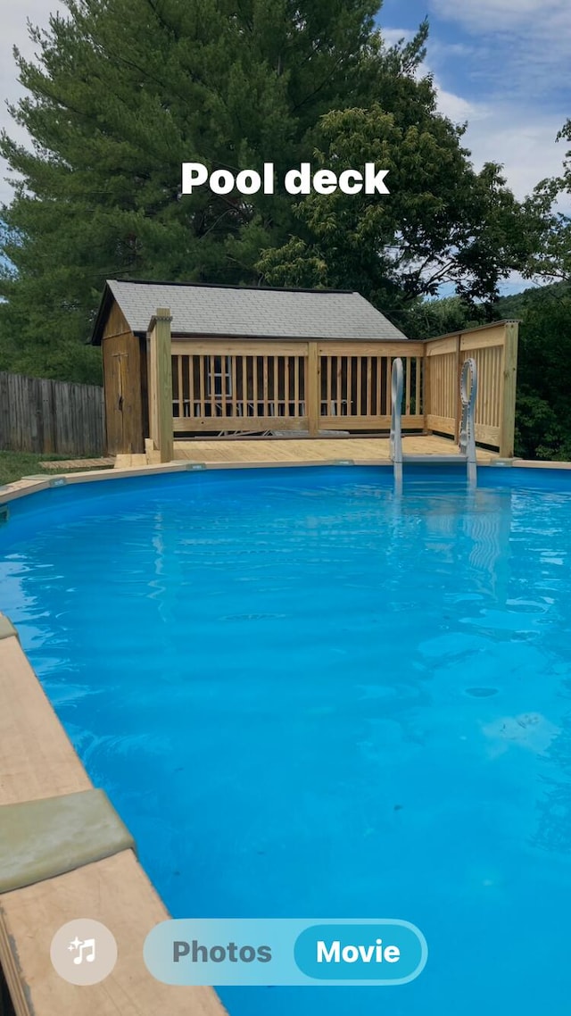 pool featuring fence and an outdoor structure