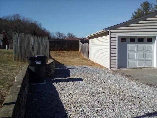 view of home's exterior with a garage, an outbuilding, and fence