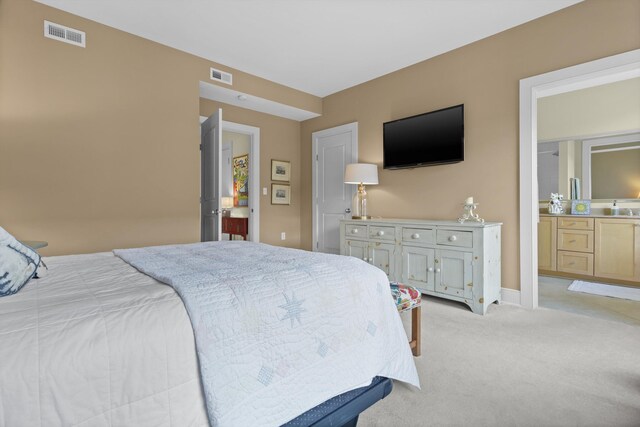 bedroom featuring light carpet, connected bathroom, visible vents, and baseboards