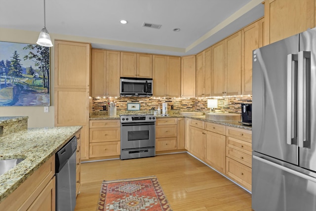 kitchen with tasteful backsplash, visible vents, light wood-style flooring, stainless steel appliances, and light brown cabinets