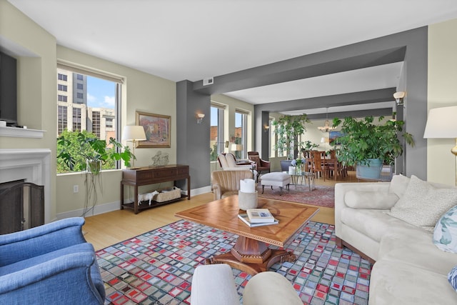 living area featuring a fireplace, baseboards, and wood finished floors