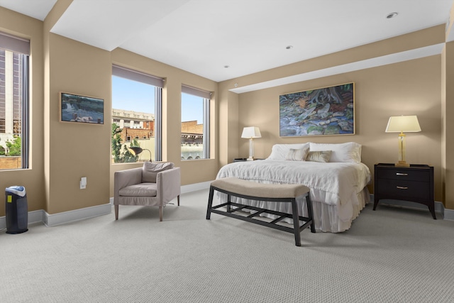 bedroom with light colored carpet and baseboards