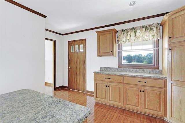 kitchen with light wood finished floors, light brown cabinets, ornamental molding, and light countertops