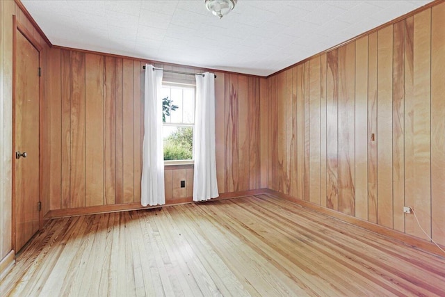 unfurnished room with hardwood / wood-style floors and wooden walls