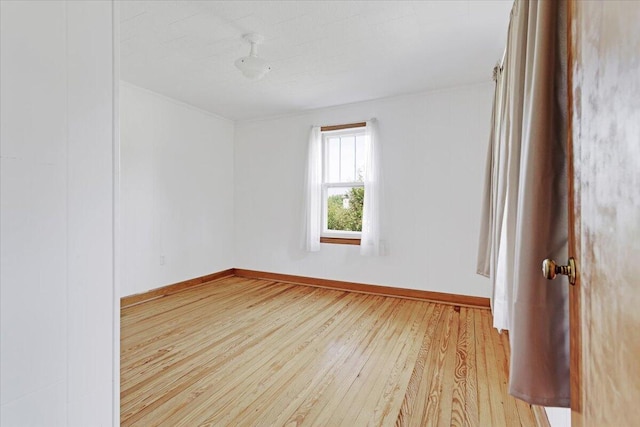 spare room with wood-type flooring and baseboards