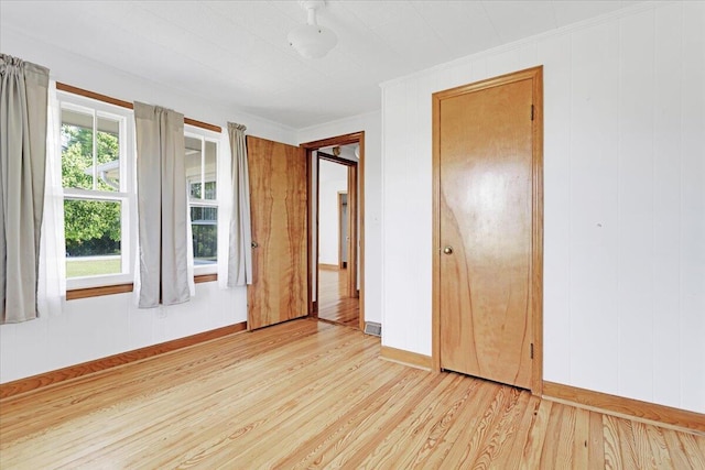 empty room featuring light wood finished floors and baseboards