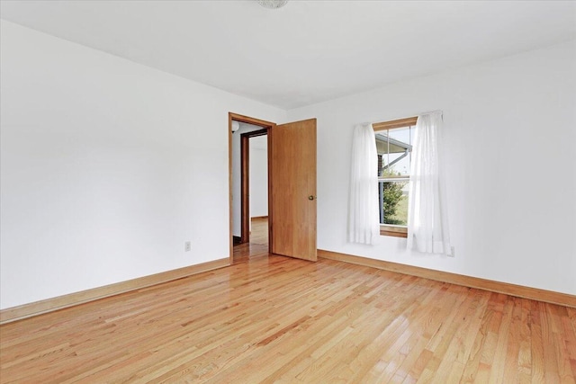 spare room with light wood-style floors and baseboards