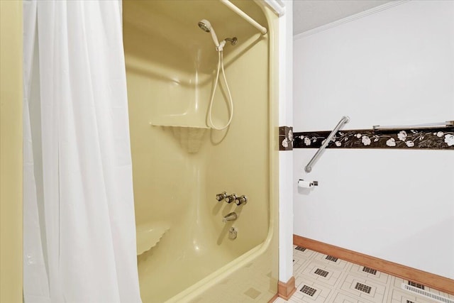 bathroom featuring crown molding, baseboards, and shower / bath combo with shower curtain