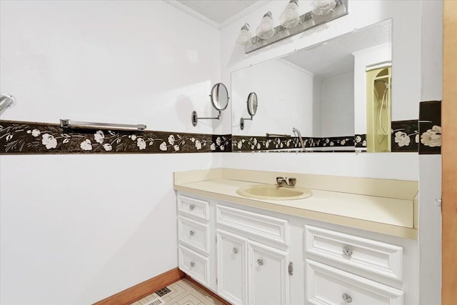 bathroom featuring baseboards, ornamental molding, and vanity