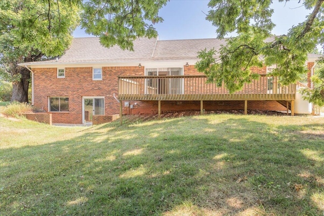 back of house with a deck, a lawn, and brick siding