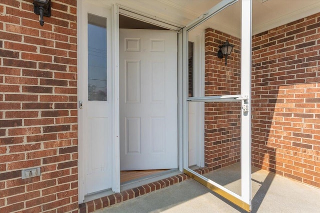 entrance to property featuring brick siding