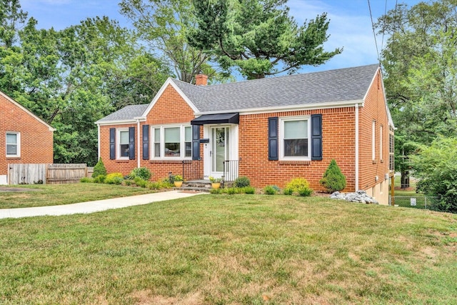 bungalow with a chimney, fence, a front lawn, and brick siding