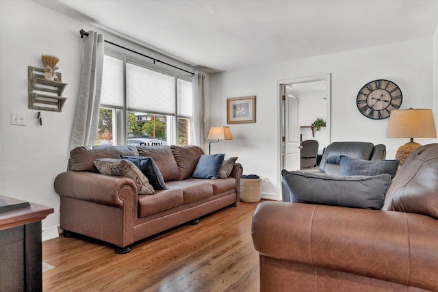 living area with light wood-type flooring and baseboards