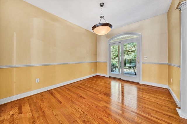 unfurnished room with baseboards and wood finished floors