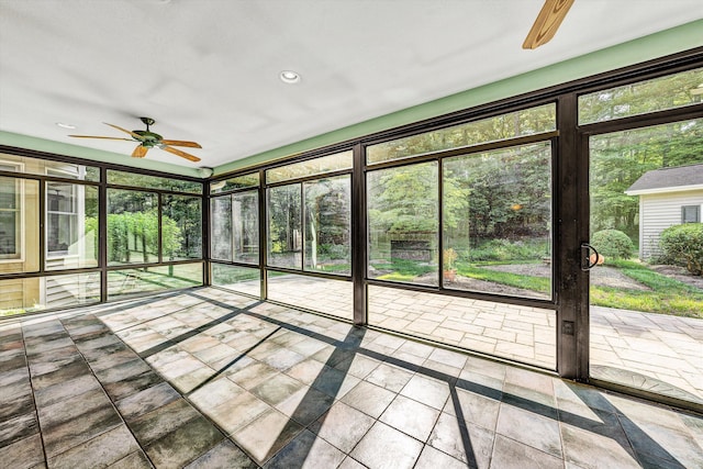 unfurnished sunroom featuring a ceiling fan