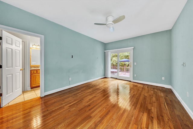 empty room featuring light wood-style floors, ceiling fan, and baseboards