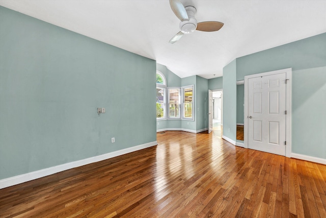 unfurnished room with ceiling fan, vaulted ceiling, wood-type flooring, and baseboards