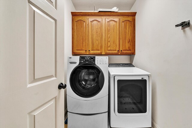 laundry area with cabinet space and separate washer and dryer