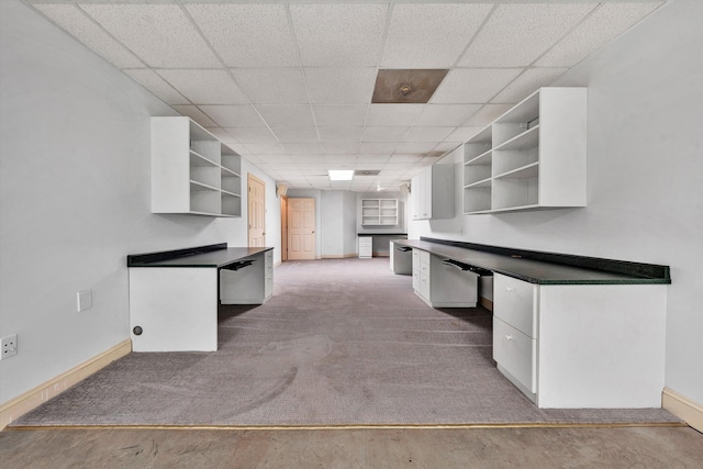 kitchen with white cabinets, a drop ceiling, open shelves, and built in desk