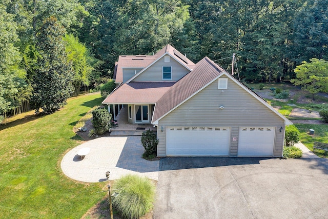 view of front of property featuring driveway, a garage, a porch, and a front lawn