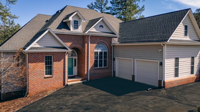 view of front facade featuring driveway, a garage, and brick siding