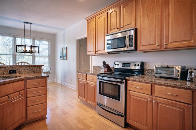 kitchen featuring appliances with stainless steel finishes, dark stone countertops, and a sink