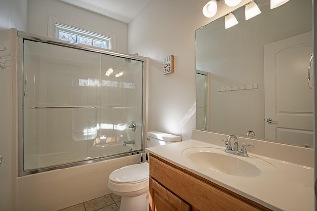 bathroom with enclosed tub / shower combo, vanity, toilet, and tile patterned floors