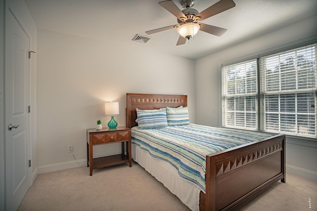 bedroom featuring multiple windows, baseboards, and light colored carpet