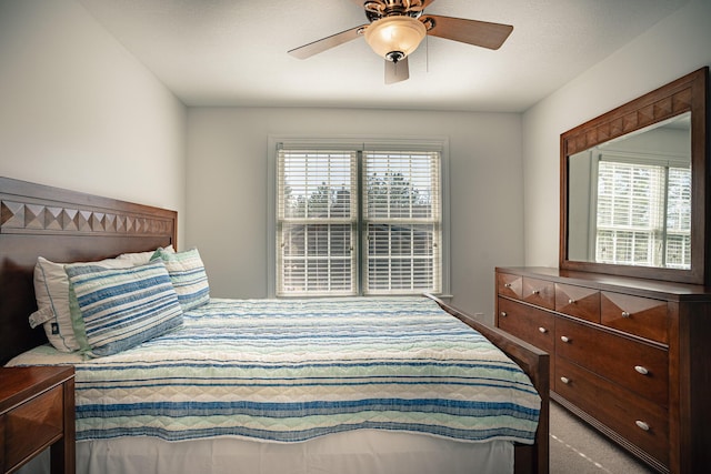 carpeted bedroom featuring multiple windows and a ceiling fan