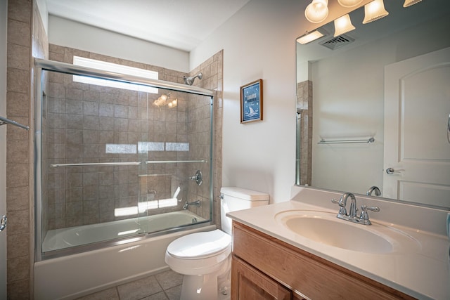 full bathroom with shower / bath combination with glass door, visible vents, toilet, vanity, and tile patterned floors