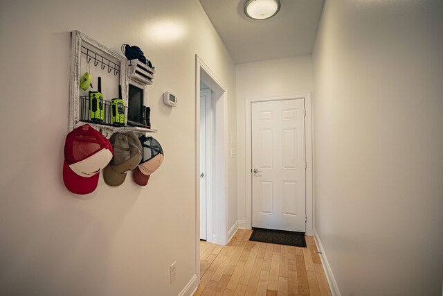 doorway featuring light wood-style flooring and baseboards