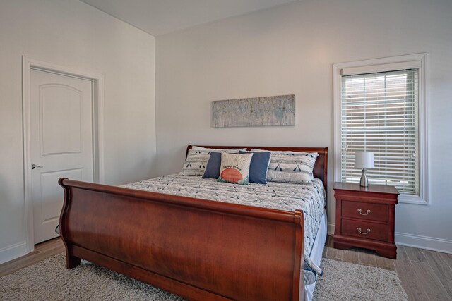 bedroom with baseboards and wood finished floors