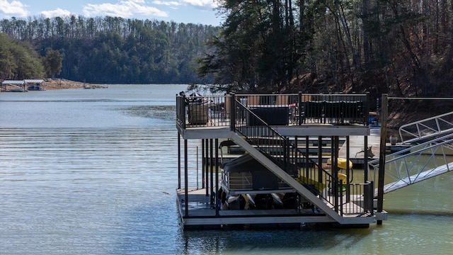 view of dock featuring a water view and a wooded view