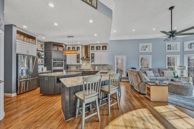20 Waverly Ct, Moneta, VA 24121 - kitchen featuring a kitchen bar, a kitchen island, stainless steel appliances, wall chimney range hood, and ceiling fan