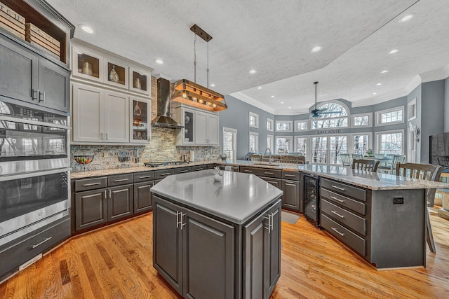 20 Waverly Ct, Moneta, VA 24121 - kitchen with a center island, beverage cooler, appliances with stainless steel finishes, wall chimney exhaust hood, and a ceiling fan