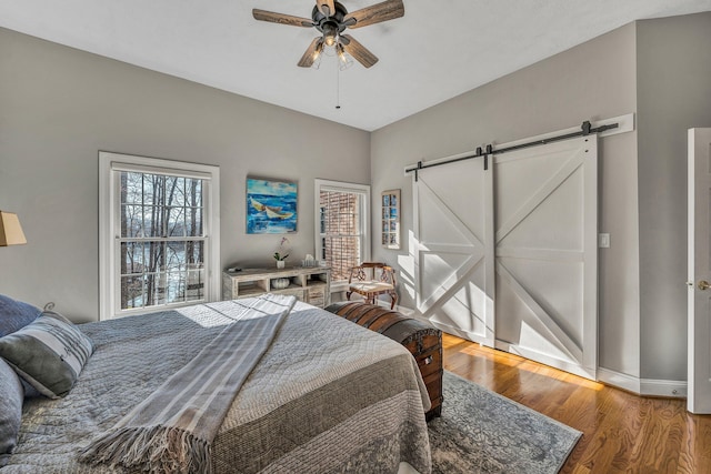 20 Waverly Ct, Moneta, VA 24121 - bedroom with a barn door, baseboards, wood finished floors, and a ceiling fan