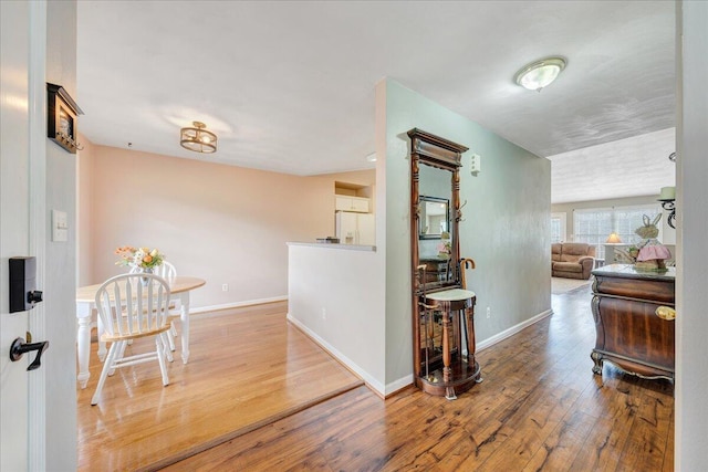 hallway featuring baseboards and hardwood / wood-style flooring