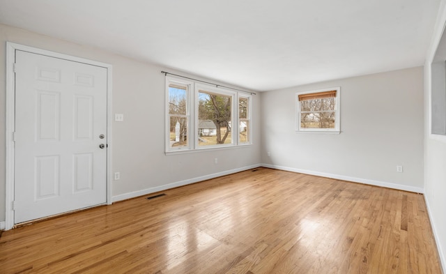 interior space with light wood-type flooring, visible vents, and baseboards