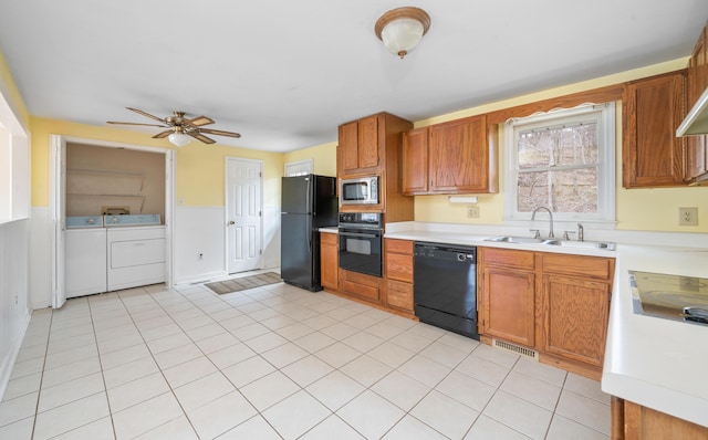 kitchen featuring independent washer and dryer, light countertops, a sink, and black appliances