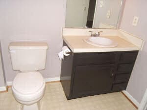 bathroom featuring toilet, vanity, and baseboards