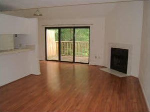 unfurnished living room featuring a fireplace with flush hearth and wood finished floors