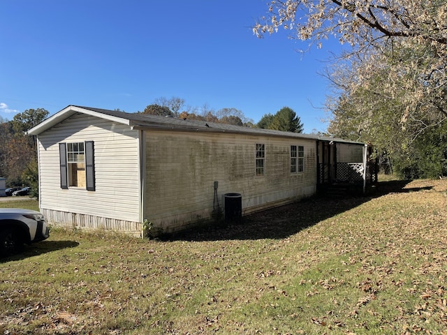 view of side of property featuring a lawn and central air condition unit