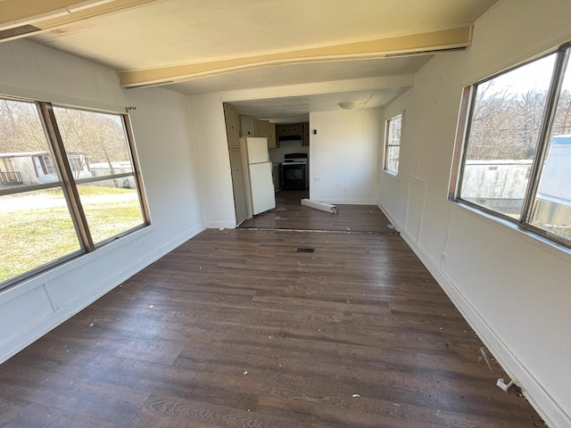 interior space featuring beamed ceiling, dark wood-style flooring, and baseboards