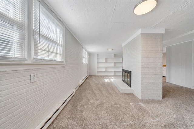 unfurnished living room featuring carpet floors, a brick fireplace, a baseboard heating unit, and a textured ceiling