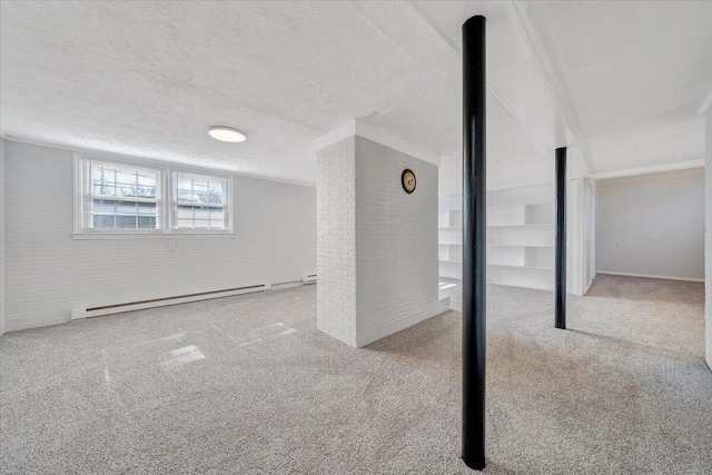 basement with a textured ceiling, carpet floors, baseboard heating, and brick wall