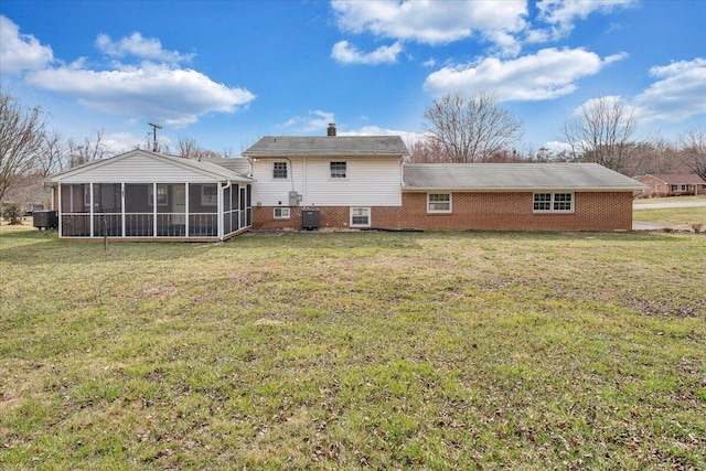 back of property featuring central AC unit, a lawn, a chimney, and a sunroom