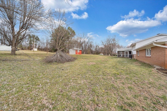 view of yard featuring an outbuilding, a sunroom, and a shed