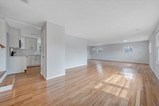 unfurnished living room featuring light wood-style flooring and baseboards